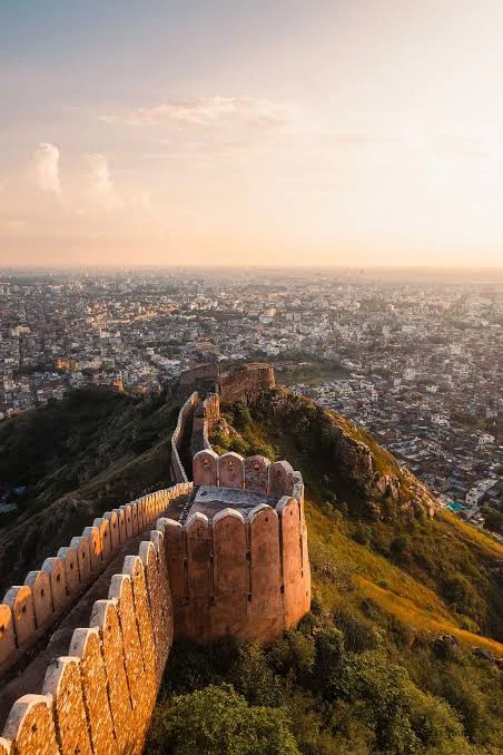 A Rajasthan fort glowing at sunset above desert dunes