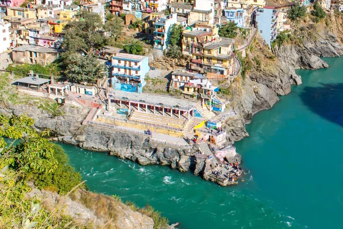 A colourful hill town above a turquoise river in Uttarakhand